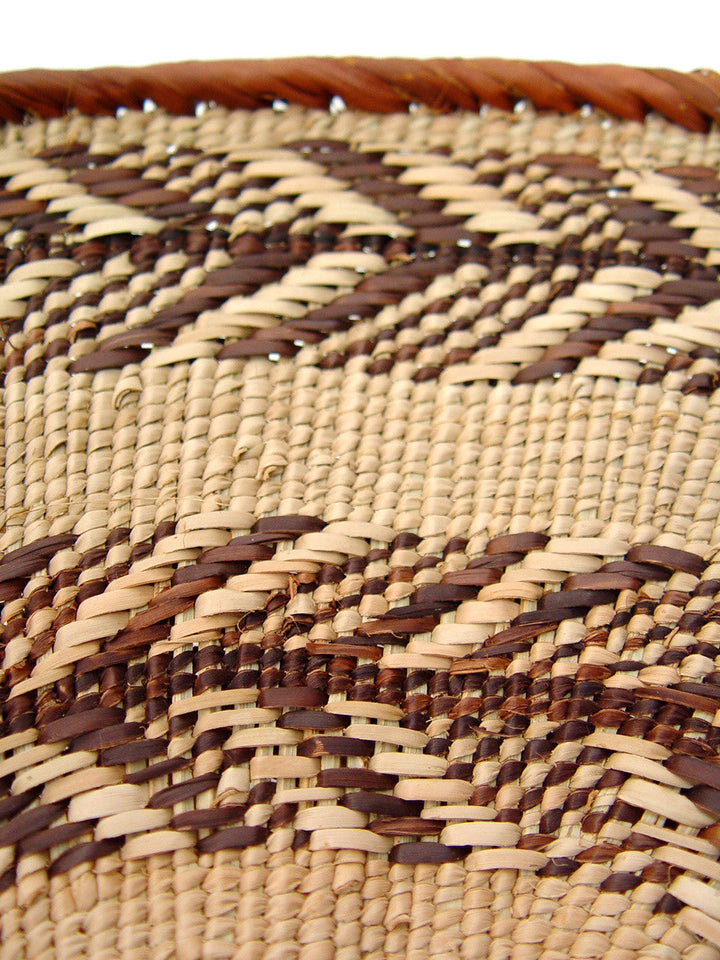 Woven basket surface with tight crisscross reeds in cream and dark brown stripes