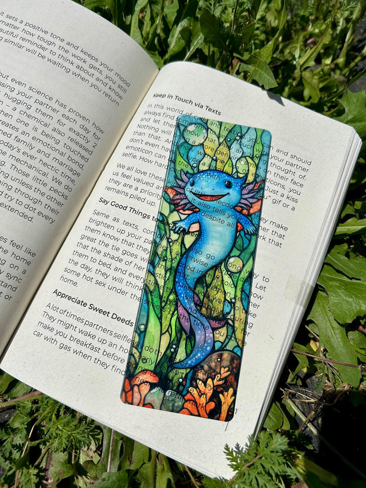 Blue axolotl bookmark with two axolotl faces on a lined book page