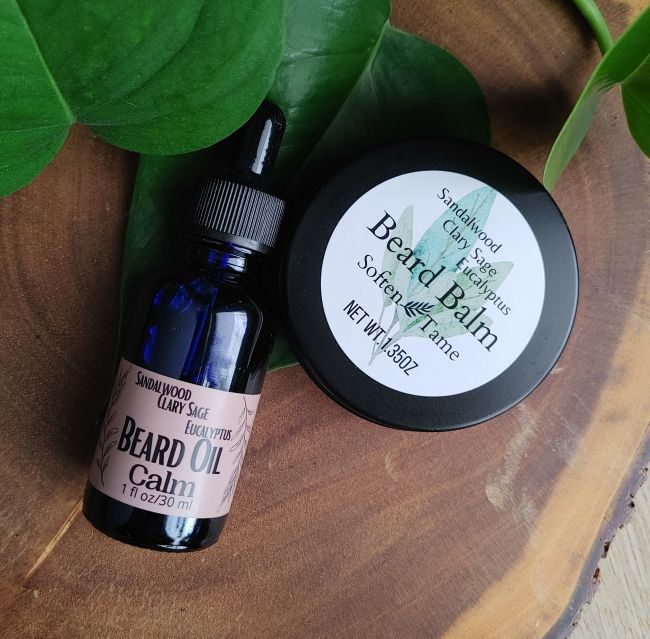 Beard oil bottle and round beard balm tin with Sandalwood Sage Calm label.
