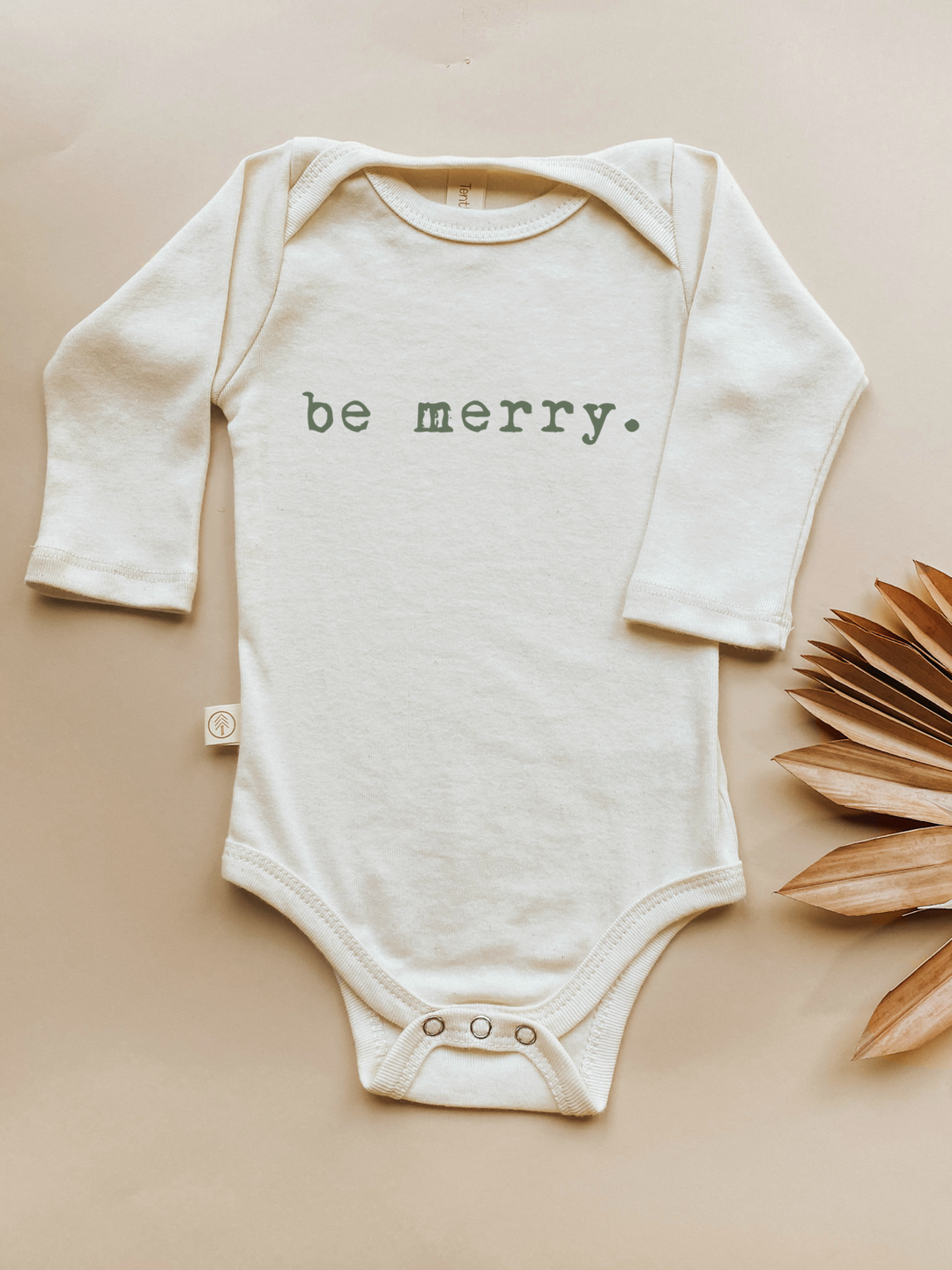 Long-sleeve baby bodysuit in cream with green "be merry" front print