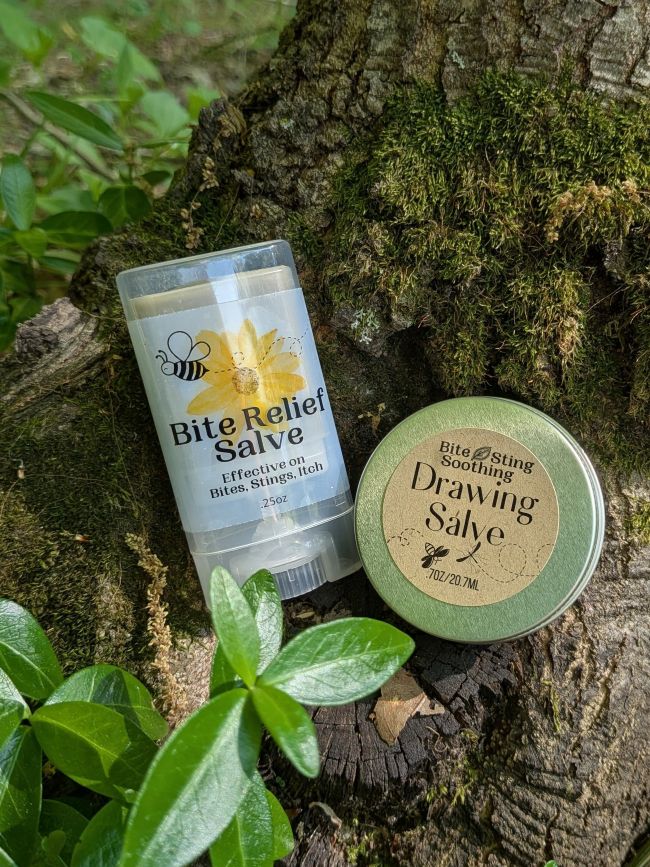 Activated charcoal bite relief drawing salve tin and lip-balm tube on display