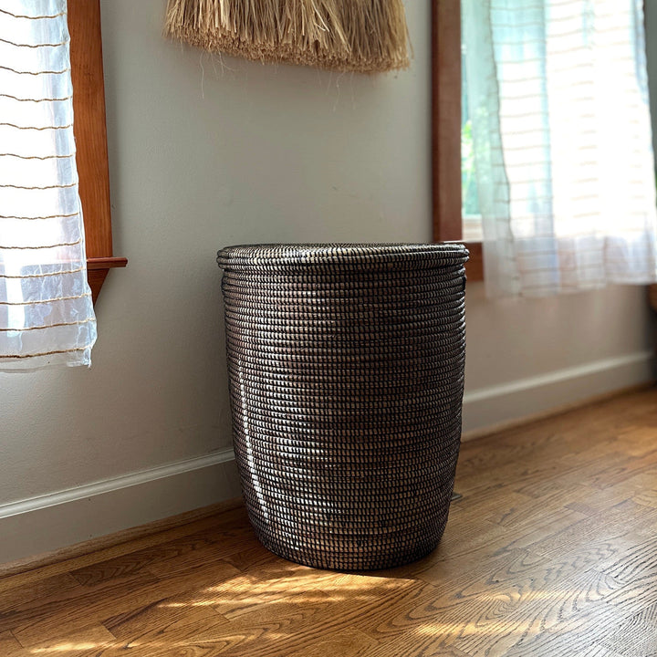 Woven dark lidded basket with flat top and braided texture