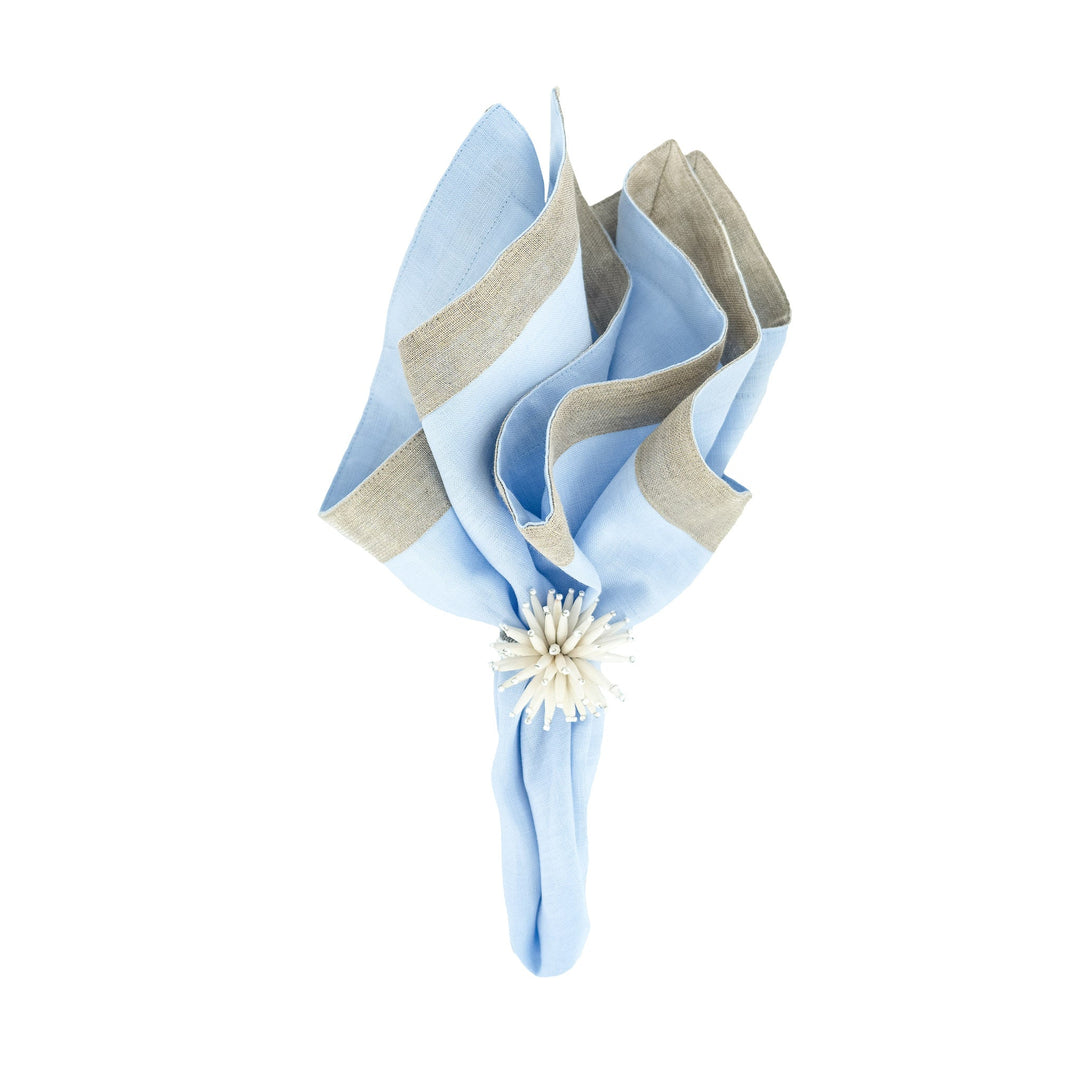 Light blue linen napkin with beige border trim, tied with white flower