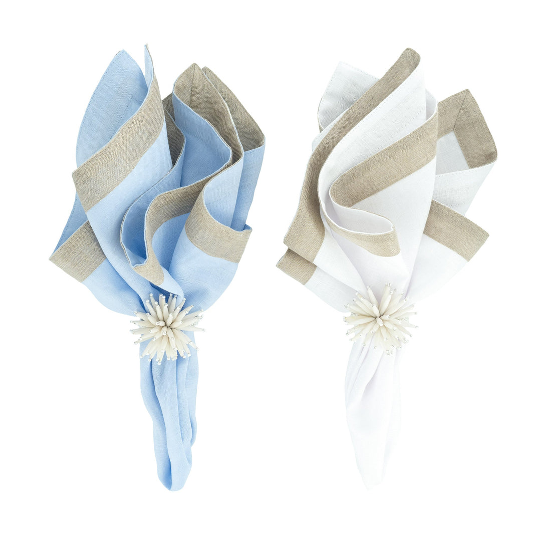 Folded napkins with beige border trim, one light blue and one white, floral ties