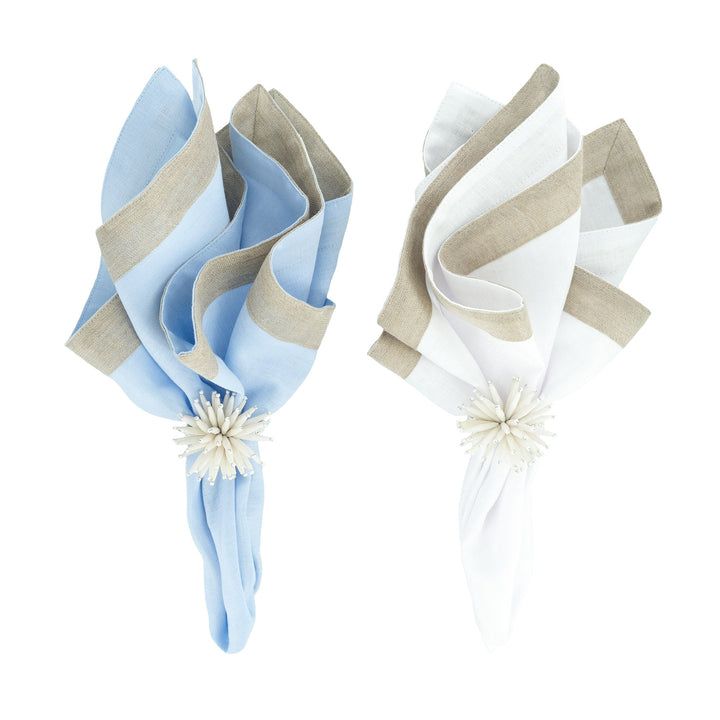 Folded napkins with beige border trim, one light blue and one white, floral ties