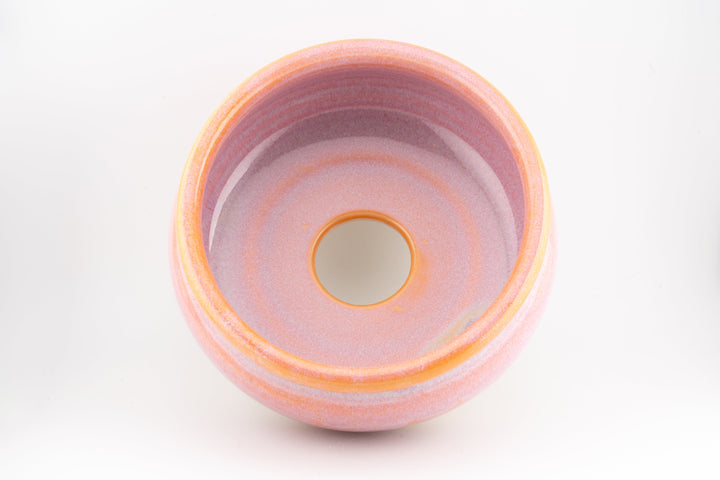 Ceramic bonsai pot top view with pink interior glaze and orange glazed rim.