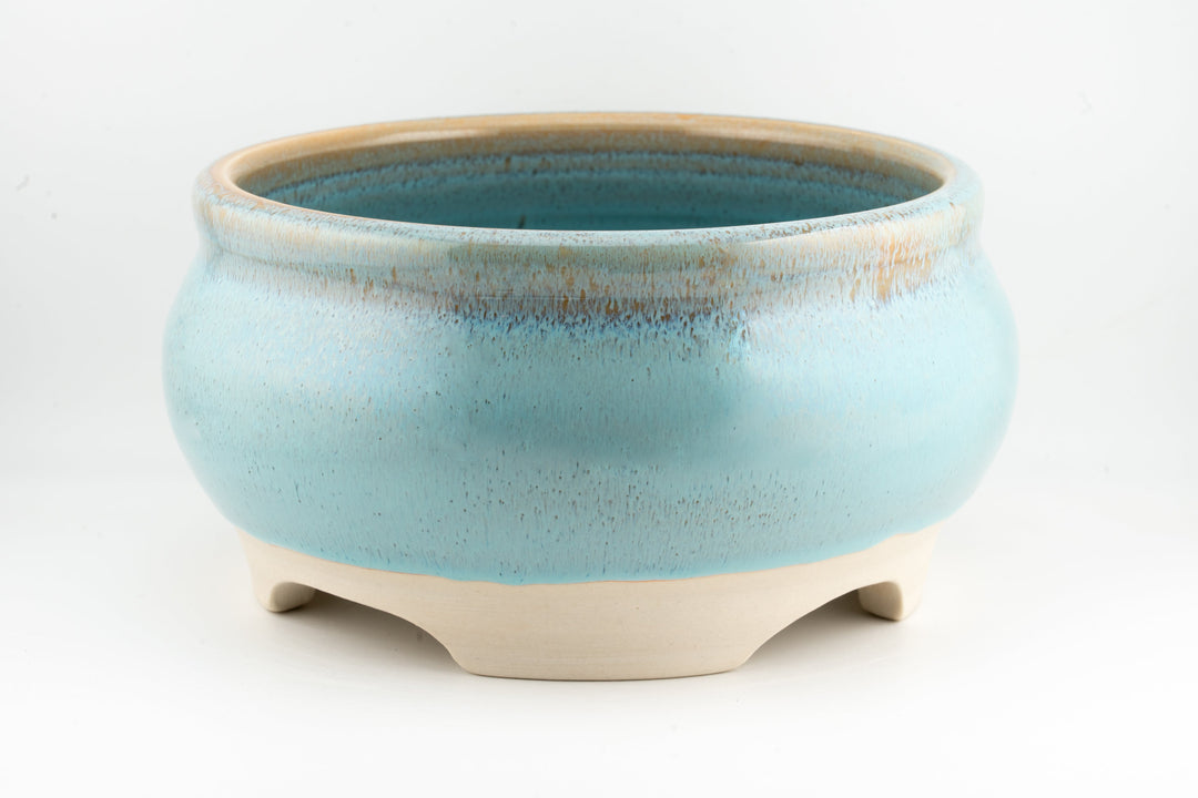Ceramic bonsai pot in light blue glaze with rounded rim and three feet.