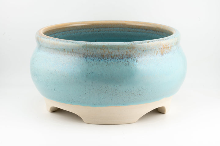 Ceramic bonsai pot in light blue glaze with rounded rim and three feet.