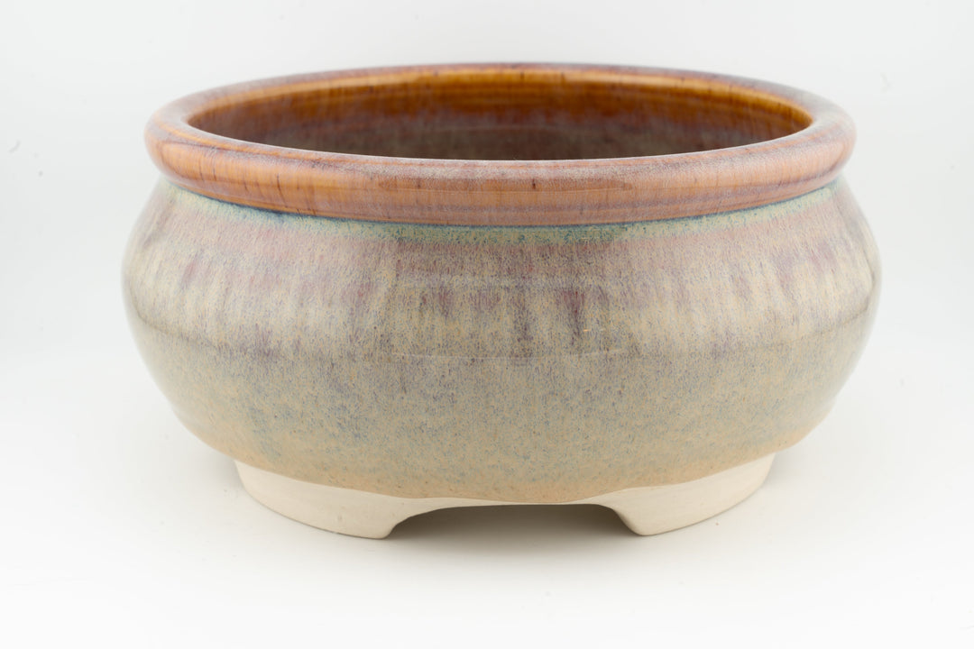 Ceramic bonsai pot in muted beige-gray glaze with brown outer rim and three feet.