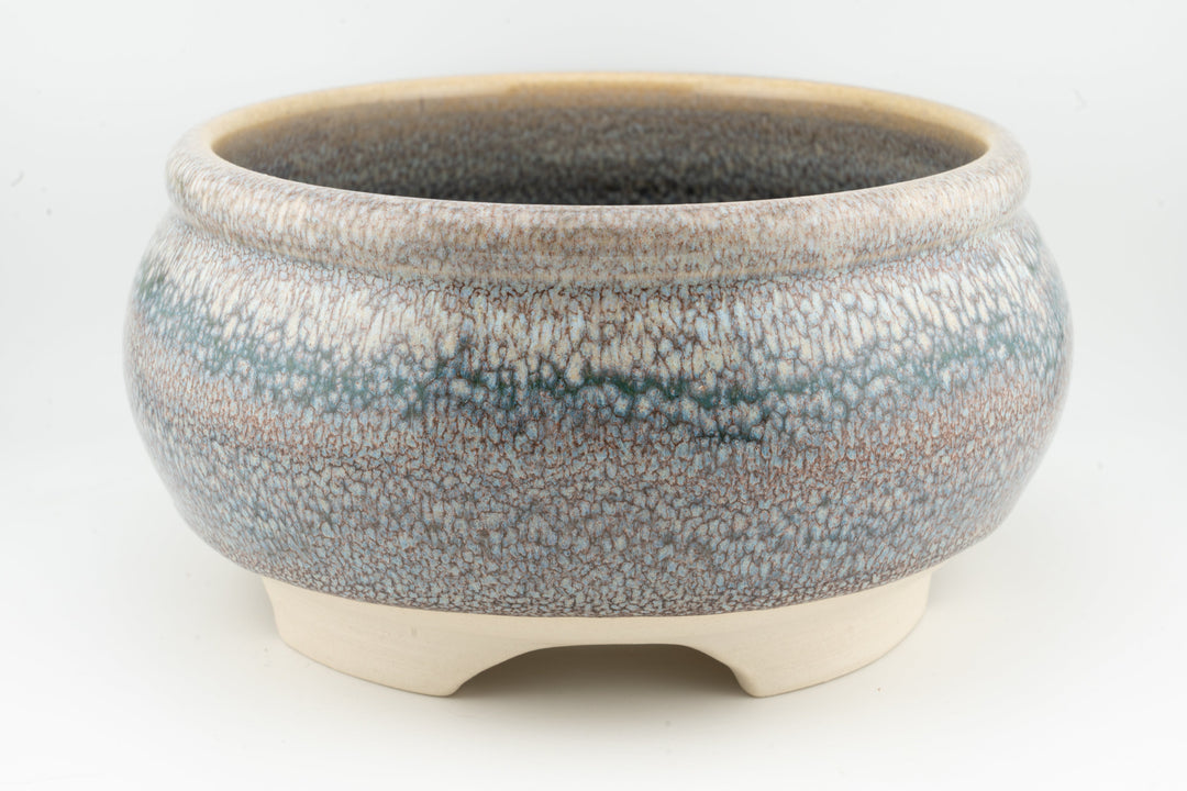 Ceramic bonsai pot with speckled blue-gray glaze, rounded body, and three feet.