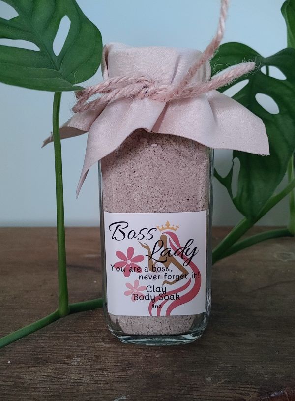 Glass jar filled with pink clay body soak powder, tied with a fabric bow and label.