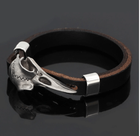 Black leather bracelet with silver-tone raven skull centerpiece and snap clasp