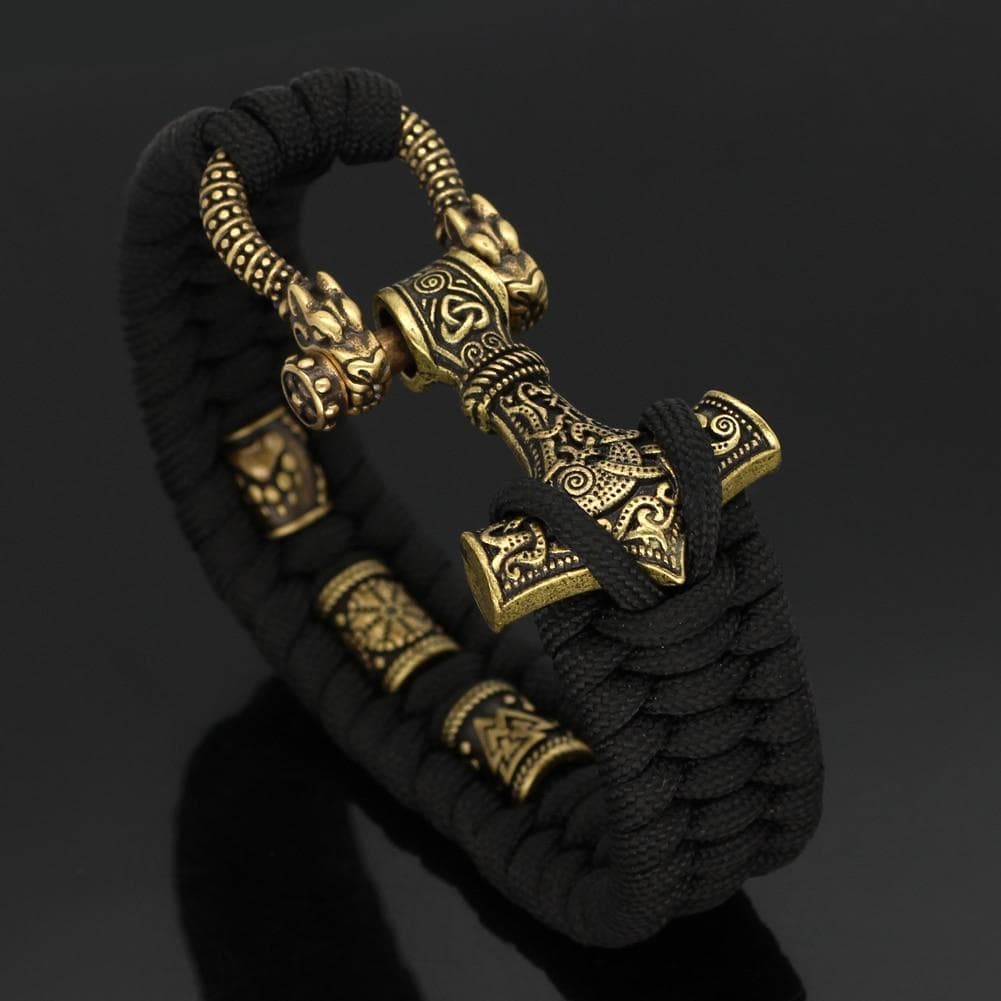 Black paracord bracelet with gold-toned hammer pendant and engraved bead accents