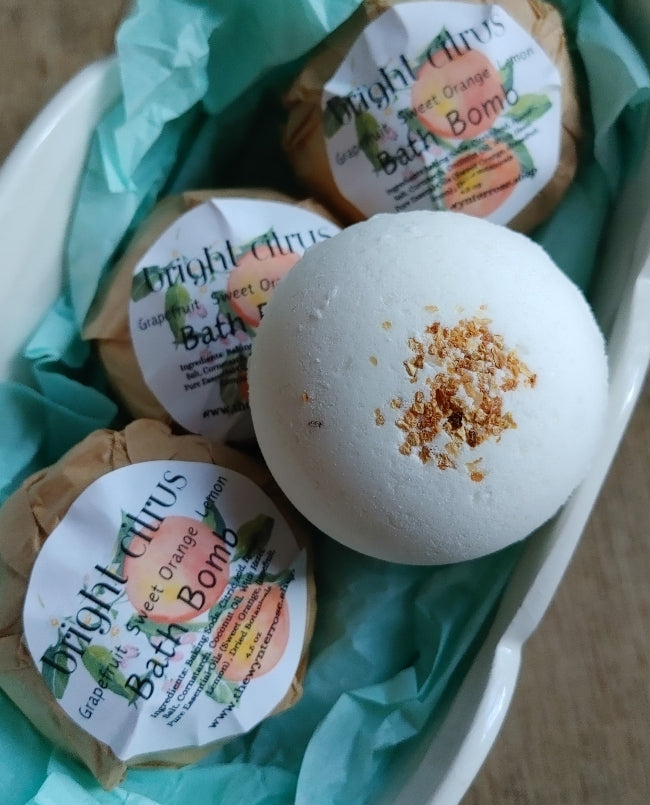 Bagged set of white round bath bombs with brown citrus speckles