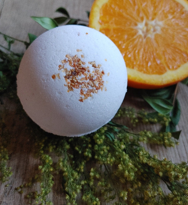 White round bath bomb with brown citrus zest speckles