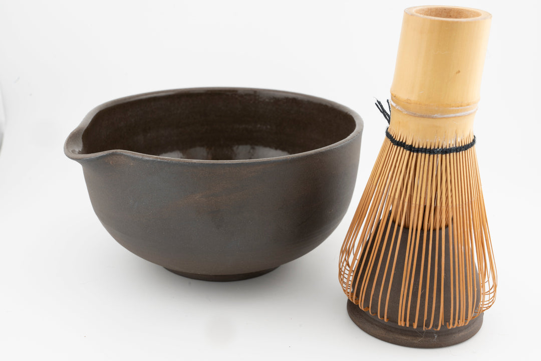 Dark brown matcha bowl with matching whisk holder and bamboo whisk set