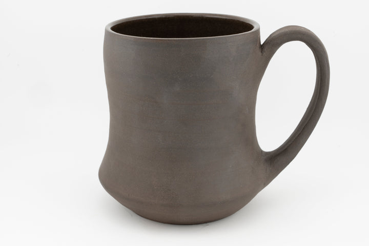 Curvy tall brown stoneware mug with side handle, unglazed matte finish