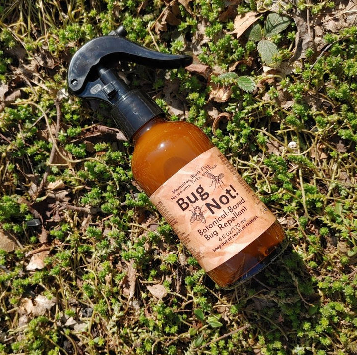 Bug Not plant-based insect repellent spray bottle with black trigger sprayer on grass