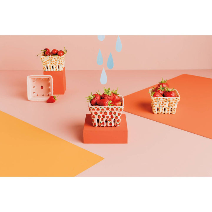 Three strawberry-pattern baskets with berries on display