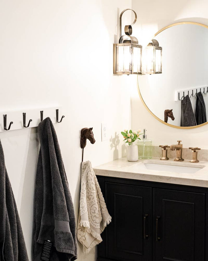 Wall-mounted iron coat hooks holding towels, set of four