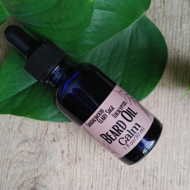 Beard oil bottle with black cap and pink label, Sandalwood Sage &