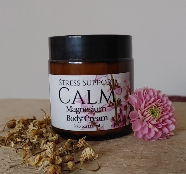 Magnesium body cream jar with black lid and amber label with pink flower design
