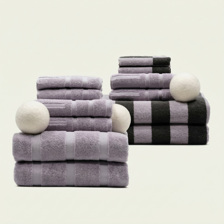 Striped cotton towels stack in lilac with dark gray accents, folded in pairs