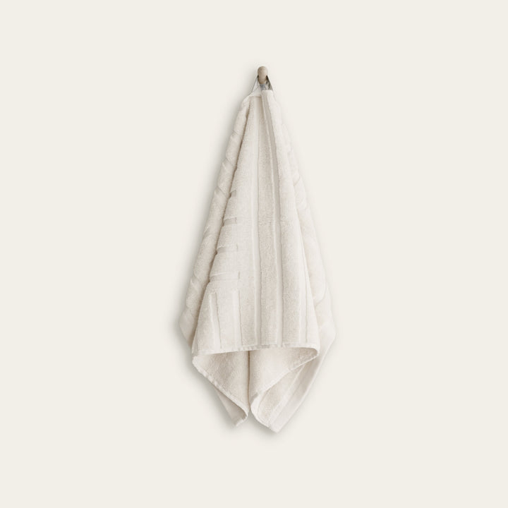 White cotton towel folded and hanging with textured woven border