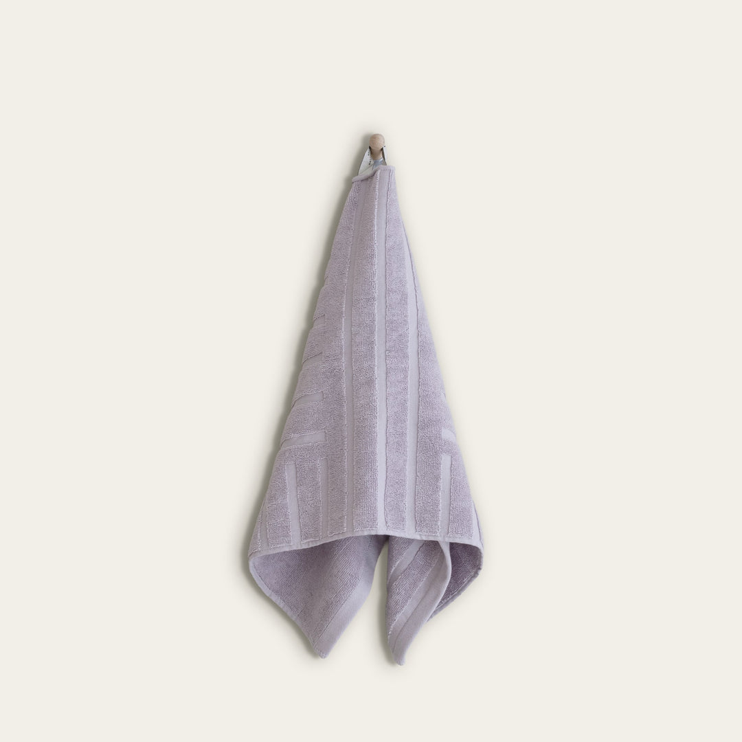 Lavender cotton towel hanging with vertical stripe pattern and terry loop texture