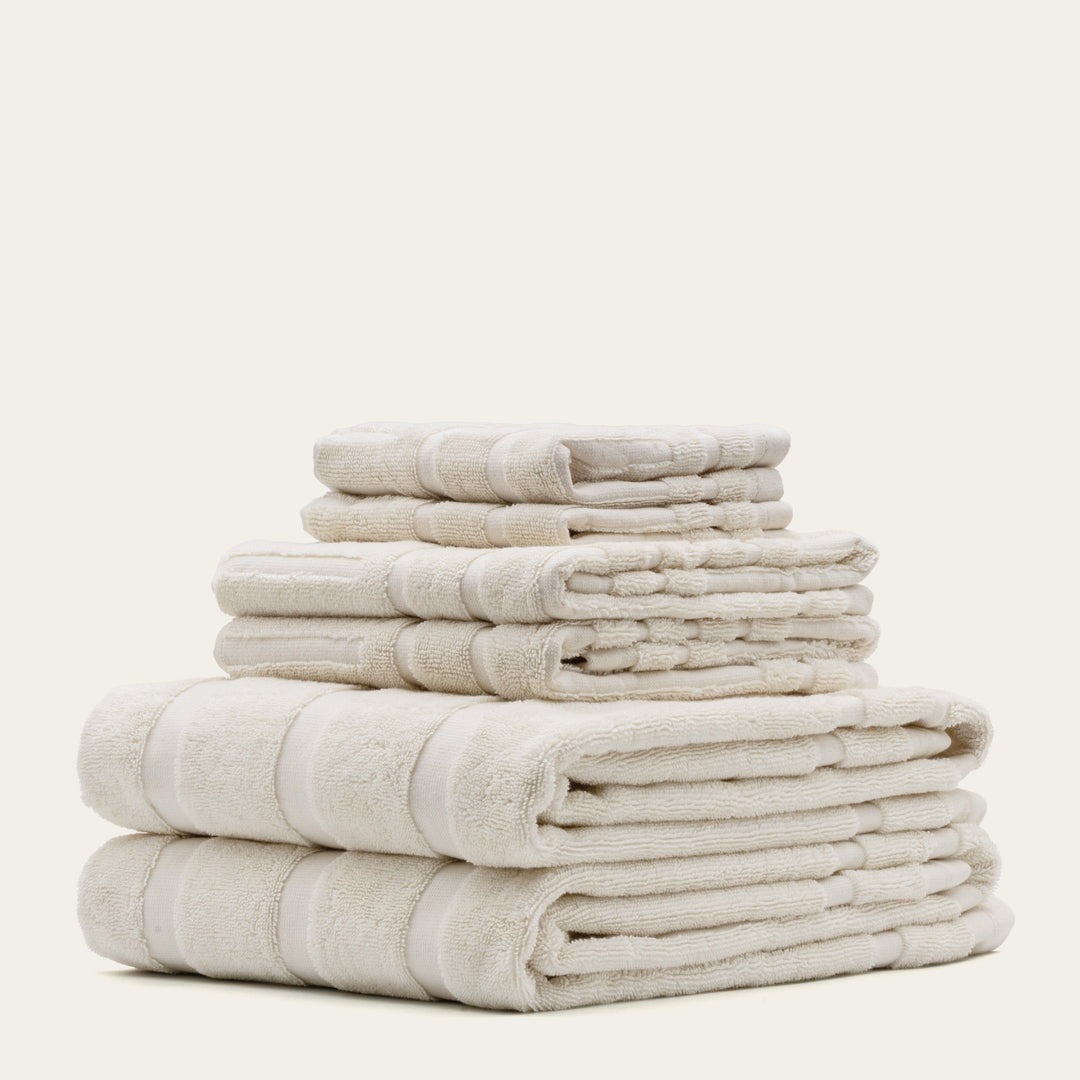 Ecru cotton towel stack, multiple folded towels with stitched edges
