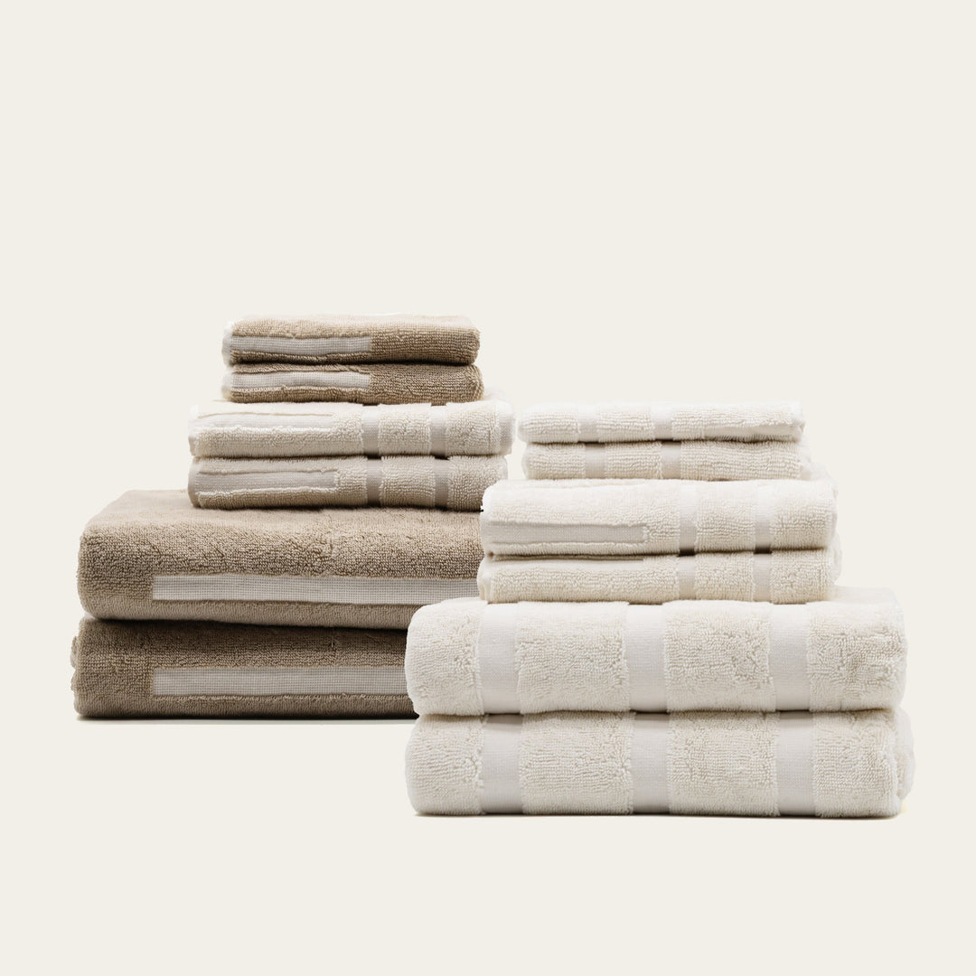 Set of cotton bath and hand towels, stacked in beige and white with folded edges