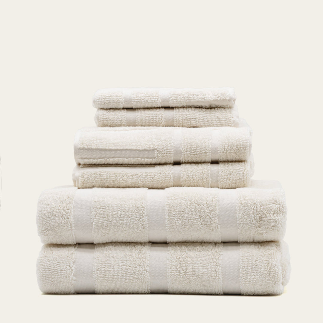 White cotton towels stacked with jacquard-style square texture bands
