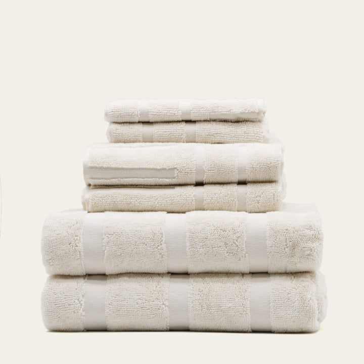 White cotton towels stacked with jacquard-style square texture bands