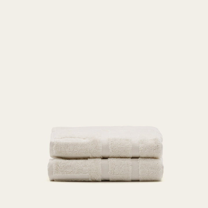 Ecru cotton hand towel set, two towels folded and banded