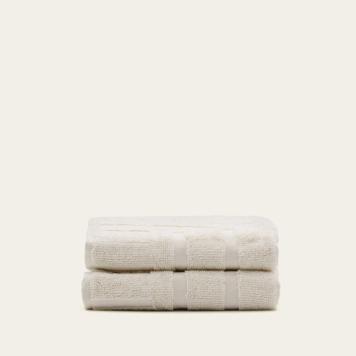 Ecru cotton towel set, two folded towels with textured border and stripes