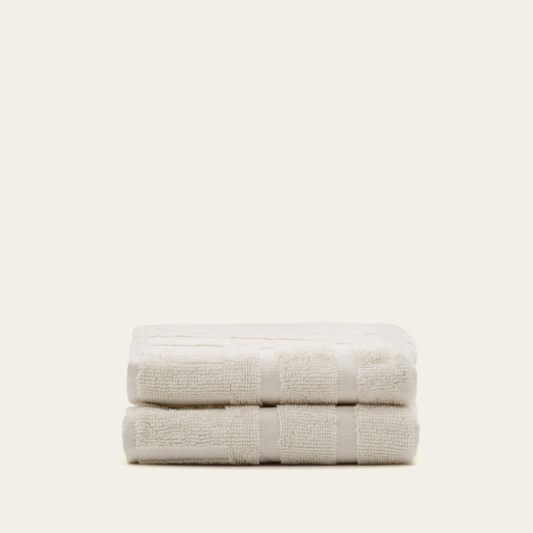 Cotton bath towel set, folded light cream towels with matching striped band detail