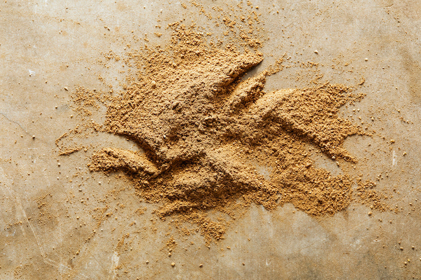 Ground brown mushroom mix powder mound in a shallow spread