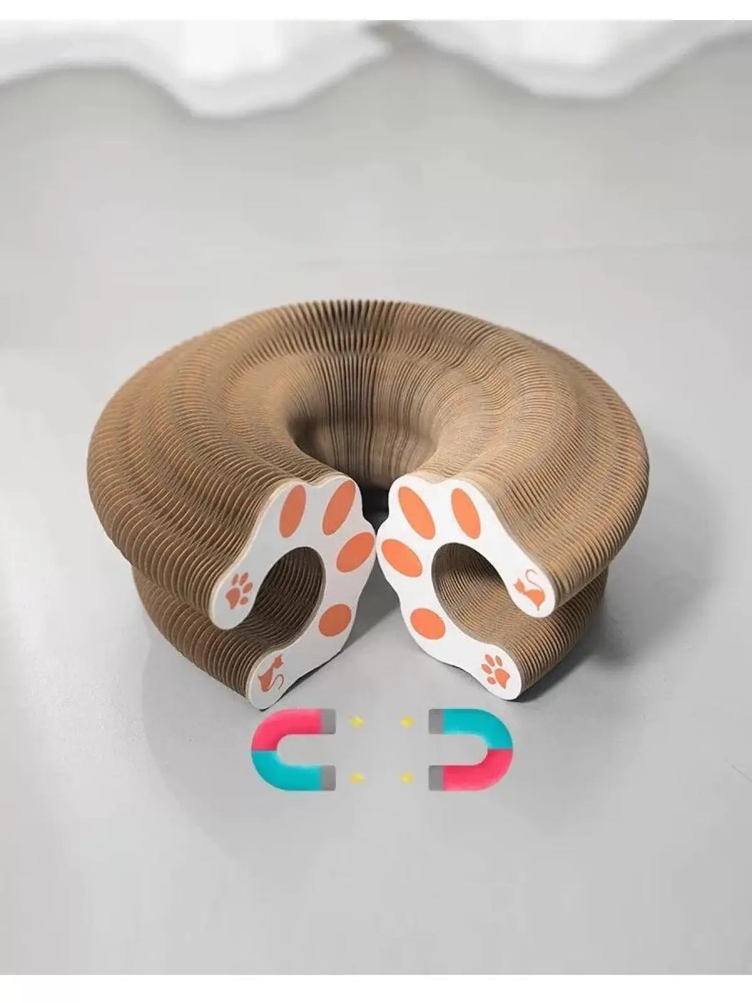 Round accordion scratching board top view with paw-print face cutouts