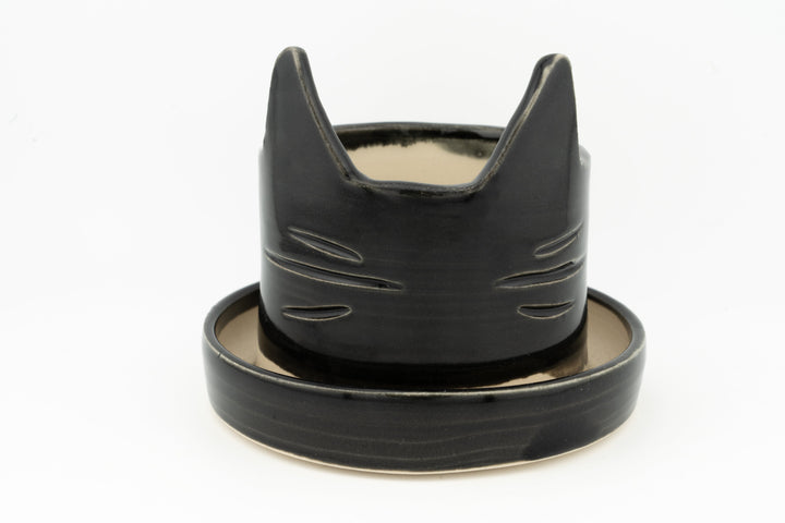 Black cat-shaped planter with matching saucer, matte-to-gloss glazed ceramic