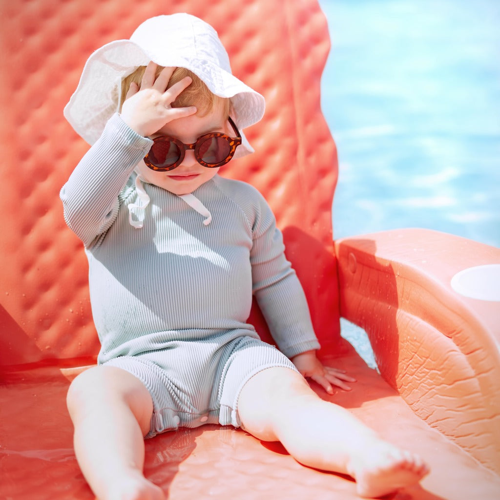 Mint ribbed long-sleeve rash guard swimsuit with shorts, sitting pose