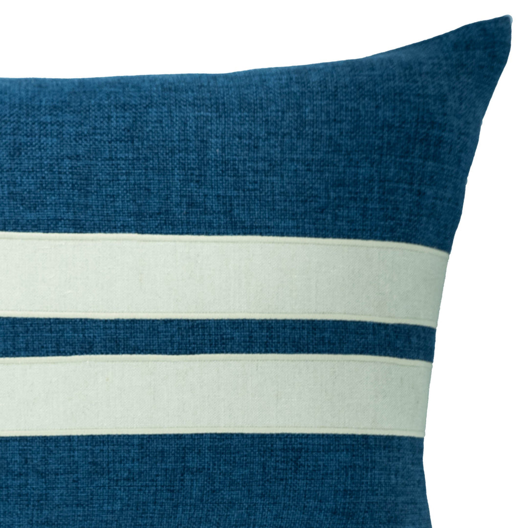 Blue throw pillow close-up with wide white stripe band across center