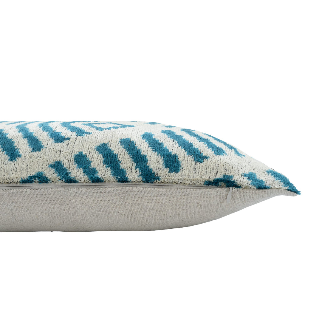 Cream ikat pillow cover with blue pattern, shown from the side