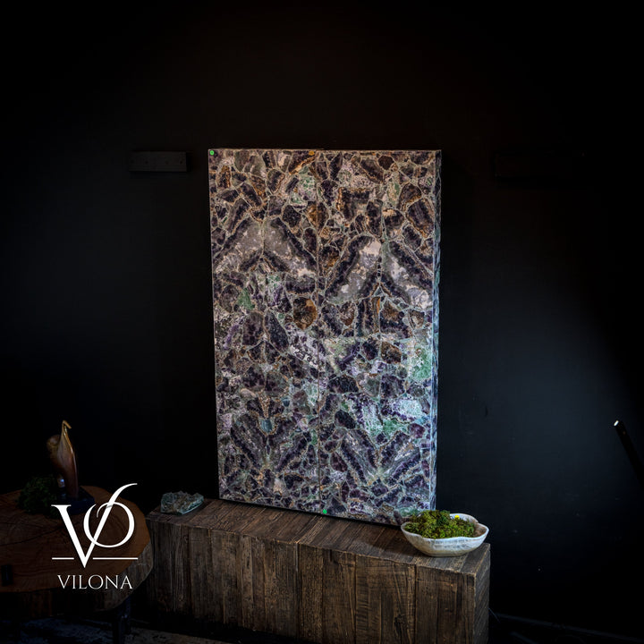 Rectangular fluorite crystal wall panel with dark speckles and vivid blue-purple highlights