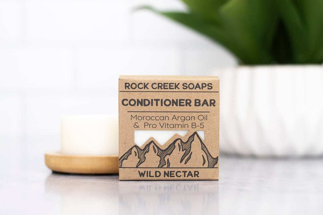Conditioner bar soap with label, white bar beside wooden soap dish, Rock Creek Soaps.