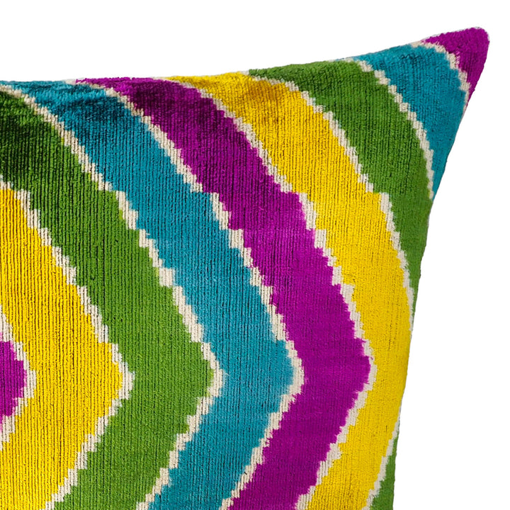 Silk velvet ikat pillow cover corner with green, purple, yellow, and blue chevron stripes