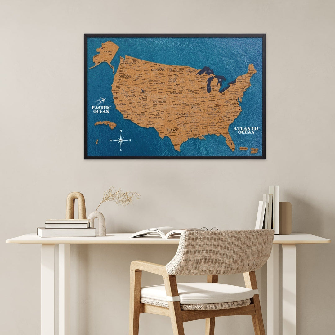 Framed blue cork USA map with Pacific Ocean and Atlantic Ocean labels on wall