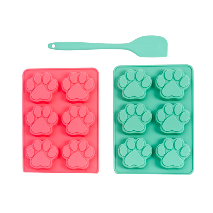 Silicone paw-print baking trays in red and green with turquoise silicone spatula
