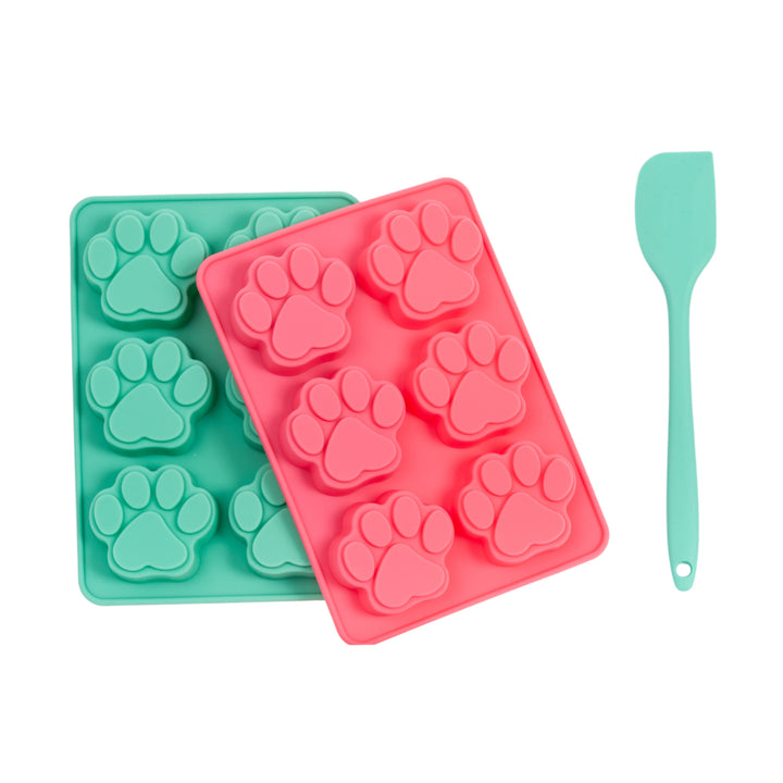 Teal silicone baking tray with paw molds, pink tray on top, plus turquoise spatula
