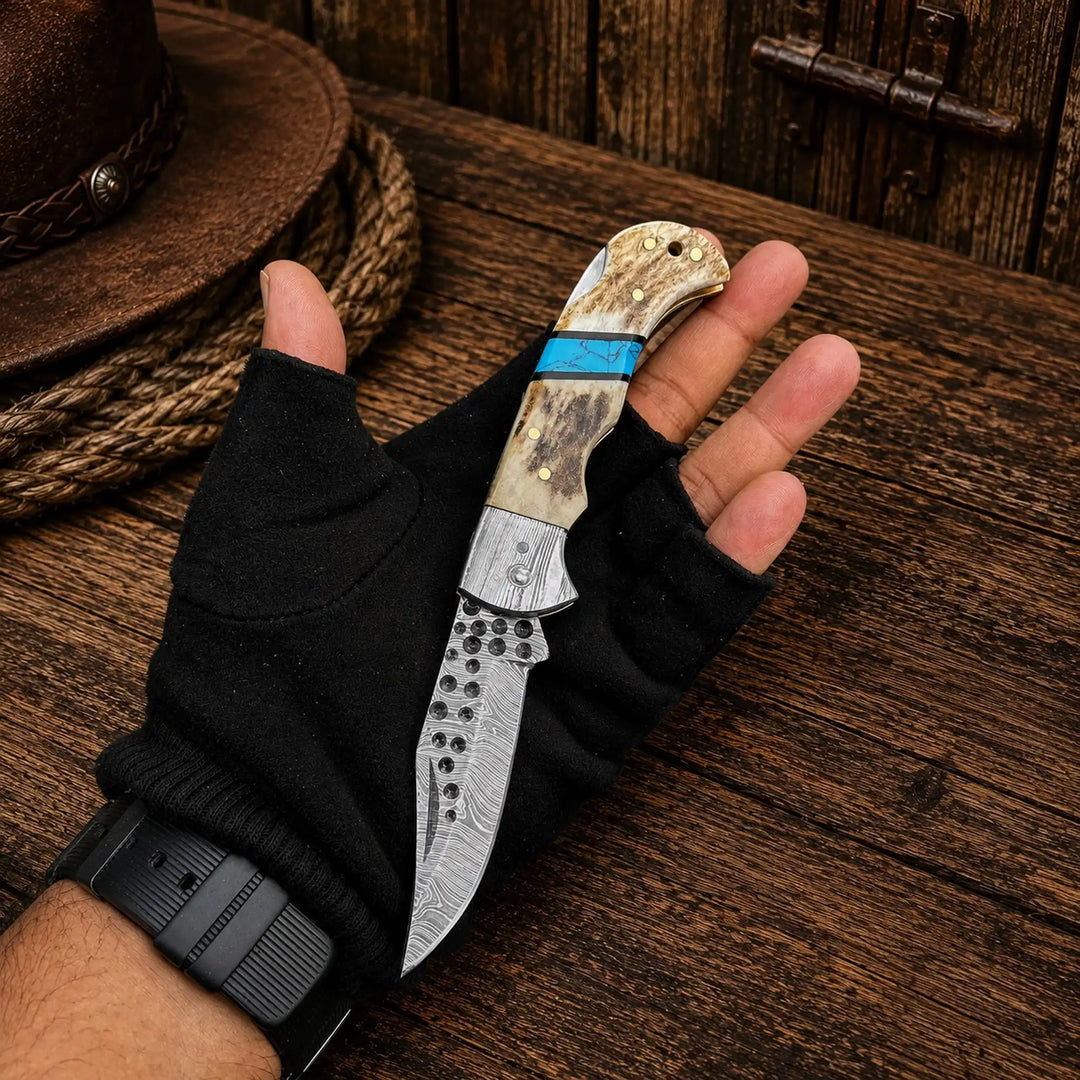 Antler and turquoise folding pocket knife with damascus blade, in hand