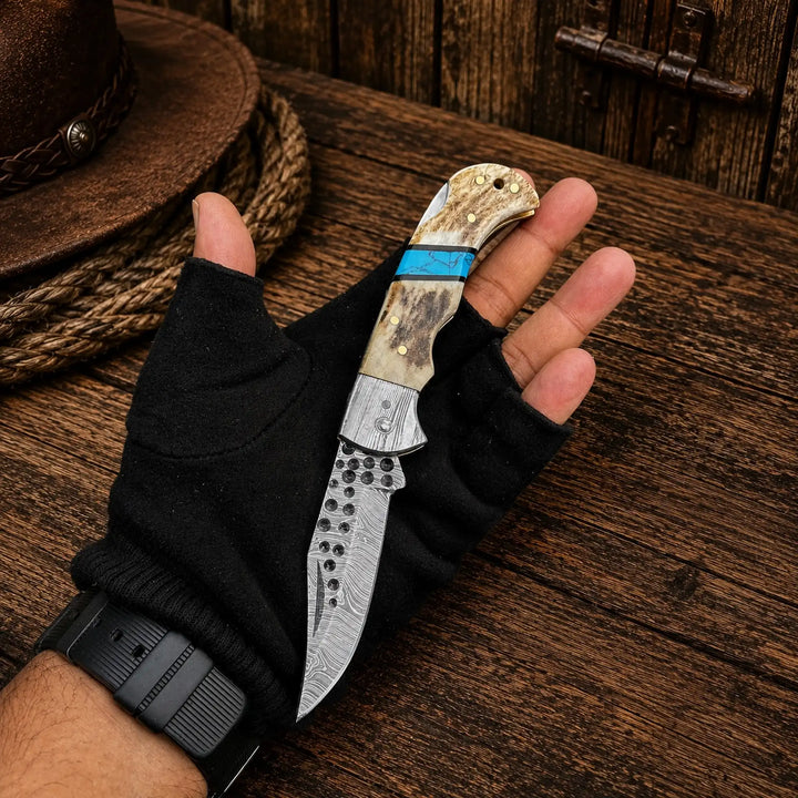 Antler and turquoise folding pocket knife with damascus blade, in hand